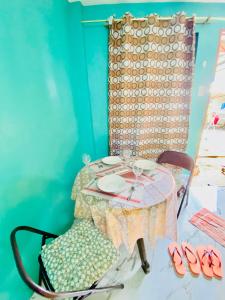 una mesa con un plato y una silla con un mantel en Budget-StudioRoom-Panabo-Homestay en Panabo