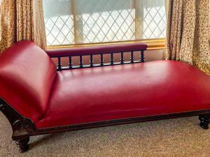 a red couch sitting in front of a window at The Lodge - Uk44556 in Plaistow