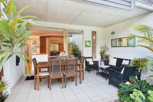 Short Stroll to White Sandy Beach في ساحة كاسوارينا: فناء على طاولة وكراسي على شرفة