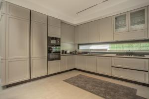 a large kitchen with white cabinets and a rug at Enclave Villa Luxury,Pool and Nature at Marmaris in Marmaris