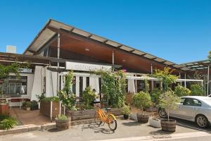 Short Stroll to White Sandy Beach في ساحة كاسوارينا: دراجة برتقالية متوقفة أمام المبنى