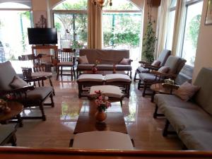 a living room with couches and chairs and a television at Karis Hotel in Kos Town