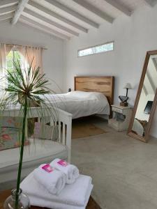 1 dormitorio con 1 cama con toallas y espejo en Casa Tenis Hotel & Club en Benavídez