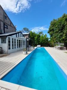 una gran piscina azul con terraza de madera en Casa Tenis Hotel & Club en Benavídez