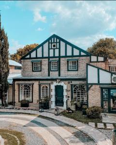 a large brick house with a black roof at Casa Tenis Hotel & Club in Benavídez
