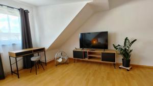 a living room with a flat screen tv and a piano at M-OASE Business Design I Küche I Parkplatz I Netflix in Braunschweig