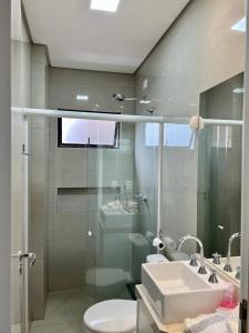 La salle de bains est pourvue d'une douche en verre et d'un lavabo. dans l'établissement Apto Próximo ao Shopping, à Foz do Iguaçu