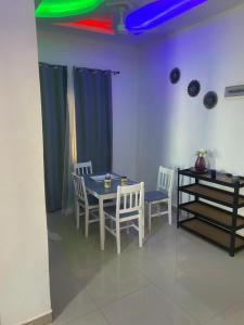 une salle à manger avec une table bleue et des chaises dans l'établissement Rahims 3 bedroom Bungalow - Dalaba, à Jarbang