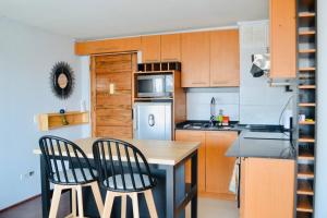 a small kitchen with a table and two chairs at Departamento muy central, a pasos de playa, bares y terminal in Viña del Mar