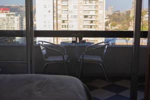 a table with two chairs in front of a window at Departamento muy central, a pasos de playa, bares y terminal in Viña del Mar