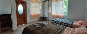 ein Schlafzimmer mit zwei Betten, einer Tür und einem Fenster in der Unterkunft Mindomundo Home in Mindo + 15 Fotos