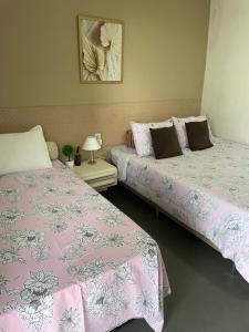 dos camas sentadas una al lado de la otra en una habitación en Pousada Alto da Serra en Serra de São Bento