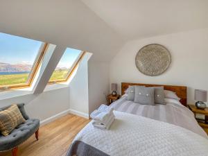 a bedroom with a large bed and two windows at Sealladh Apartment - Ukc6792 in Port Appin