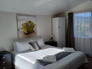 - une chambre avec un grand lit et un bol jaune dans l'établissement Golden Bay Motel, à Takaka