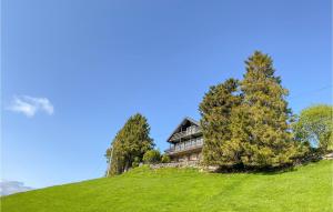 a house on top of a hill with trees at Beautiful Home In Frde With House A Panoramic View in Førde