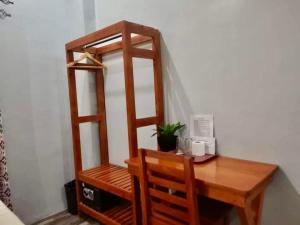 een houten bureau met een stoel en een plank bij RedDoorz at Gracia's Calzada Inn Camiguin in Mambajao