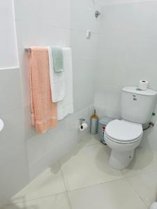 Baño blanco con aseo y toallas en Techas City Center Luxurious Suites & Rooms, en Praia