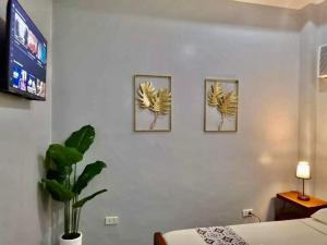 tres fotos de plátanos en la pared de un dormitorio en RedDoorz at Gracia's Calzada Inn Camiguin, en Mambajao