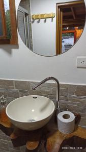 a sink in a bathroom with a mirror at Cabañas Alpina in San Agustín