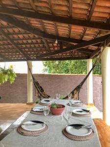 una mesa con platos y copas de vino. en Casa Cantinho Do Sossego Piri en Pirenópolis