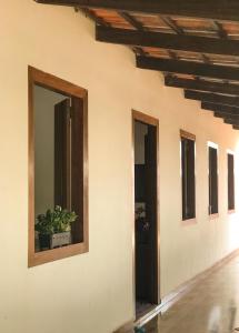 un muro con una finestra e una pianta in vaso. di Casa Cantinho Do Sossego Piri a Pirenópolis