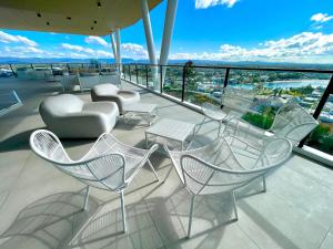 eine Gruppe von Stühlen und Tischen auf einem Balkon in der Unterkunft Ollies Place in Gold Coast