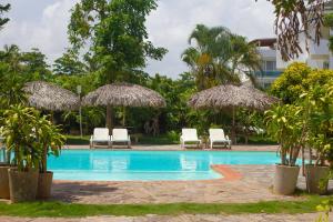 una piscina con sedie a sdraio e ombrelloni di Afreeka Beach Hotel a Las Terrenas