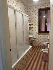 uma casa de banho com uma cabina de duche em vidro e um WC. em Villetta dei tramonti em San Feliciano