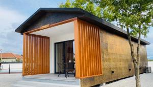 ein kleines Gebäude mit einer Veranda und einem Tisch in der Unterkunft School Motorhome Park in Óvoa