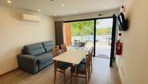 ein Wohnzimmer mit Sofa, Tisch und Stühlen in der Unterkunft School Motorhome Park in Óvoa