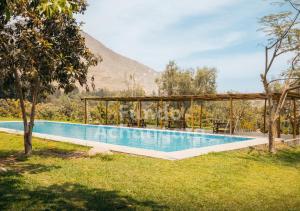 ein Schwimmbad mit einem Berg im Hintergrund in der Unterkunft Fundo Achanqara Cieneguilla in Lima