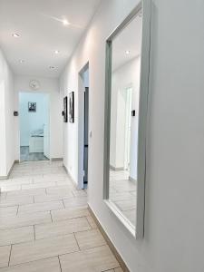 um corredor com paredes brancas e um espelho grande em 3 Zimmer Wohnung bei Frankfurt / Neu renoviert em Egelsbach