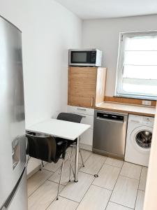 a small kitchen with a table and a microwave at 3 Zimmer Wohnung bei Frankfurt / Neu renoviert in Egelsbach