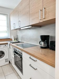 uma cozinha com armários brancos e um forno com placa de fogão em 3 Zimmer Wohnung bei Frankfurt / Neu renoviert em Egelsbach