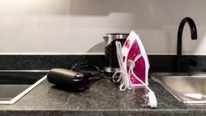 a hair dryer sitting on a counter next to a sink at THE TOKYO in Cape Town +73 photos