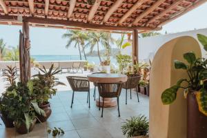 a patio with a table and chairs and a view of the ocean at Arena Suites in Zihuatanejo