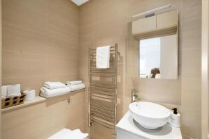 a bathroom with a sink and a mirror at Spacious and Modern 4 beds home in Kensington in London