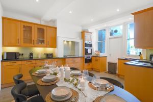 uma cozinha com uma mesa com pratos em Spacious and Modern 4 beds home in Kensington em Londres