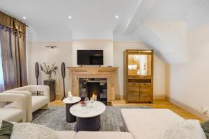 a living room with a couch and a fireplace at Spacious and Modern 4 beds home in Kensington in London