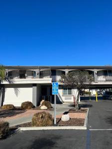 亨廷頓公園的住宿－Santa Fe Inn Los Angeles，大楼前有蓝色停车标志的停车场