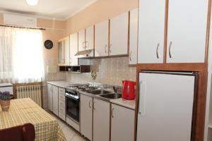 a kitchen with white cabinets and a sink and a refrigerator at Apartments with parking space Pag - 16016 in Pag