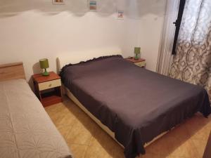 1 dormitorio con 1 cama y 2 mesas con lámparas en Apartments with a parking space Metajna, Pag - 4127, en Zubovići