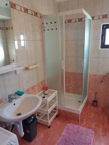 uma casa de banho com um lavatório e um chuveiro em Apartments with a parking space Metajna, Pag - 4127 em Zubovići