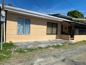 una casa gialla con finestra e strada di HOSTEL CASA MARINA a Puerto Limón