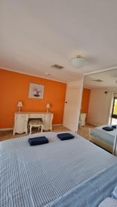 ein Schlafzimmer mit 2 Betten und einer orangefarbenen Wand in der Unterkunft Spacious Holiday Home - Waikerie in Waikerie
