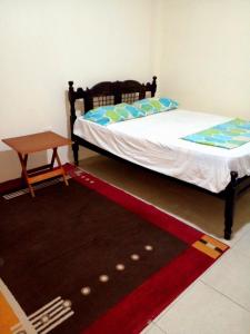 1 dormitorio con 2 camas, mesa y alfombra en Casa don rafa, en Olón