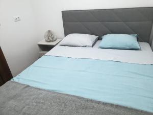 a bed with two blue pillows on top of it at Apartman Borovi Divčibare in Divčibare
