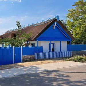 a blue and white house with a blue fence at Pensiunea Casa Golovita in Jurilovca