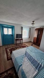 a bedroom with two beds and a blue door and a piano at Pensiunea Casa Golovita in Jurilovca