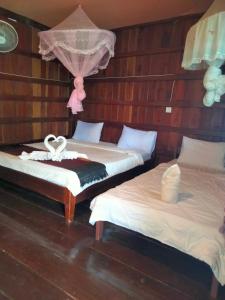 东德岛Riverside Bungalow Don Det的一间设有两张床的房间,上面有毛巾